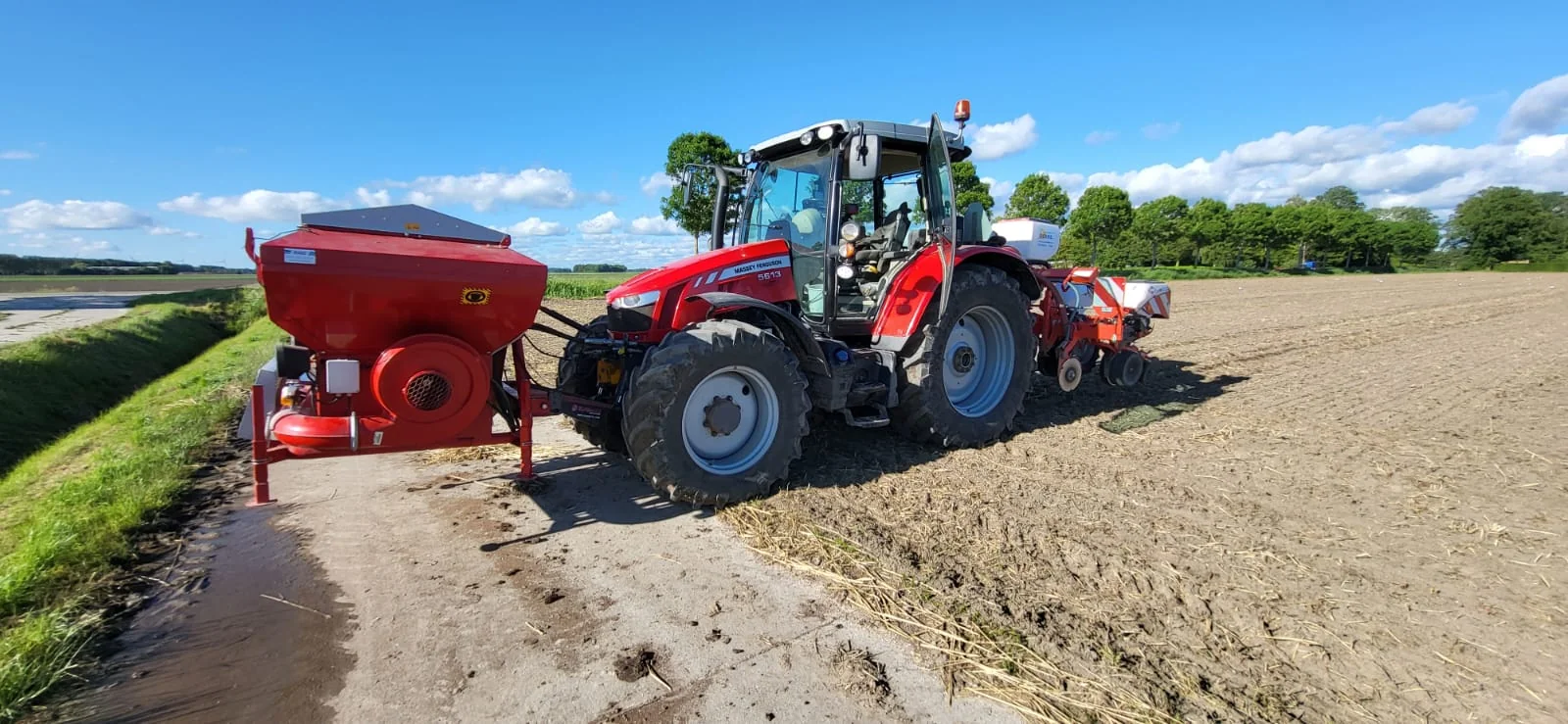 Massey Ferguson met fronttank en zaaimachine aan de rand van een akker