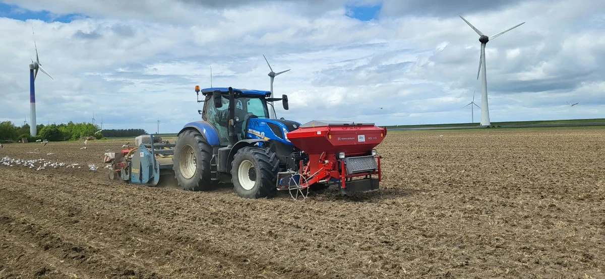 New Holland met fronttank en Imants spitmachine op een akker