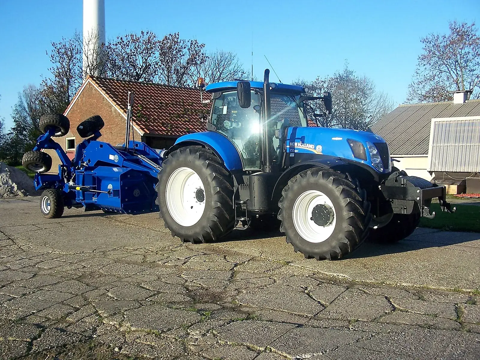 New Holland trekker met Imants spitmachine op het erf van Loonbedrijf Derks