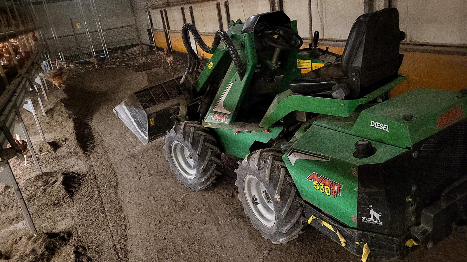 Avant minishovel met bak aan het werk in een schuur