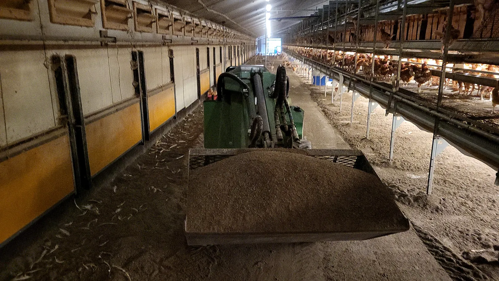 Compacte machine van Loonbedrijf Derks aan het werk in een stal