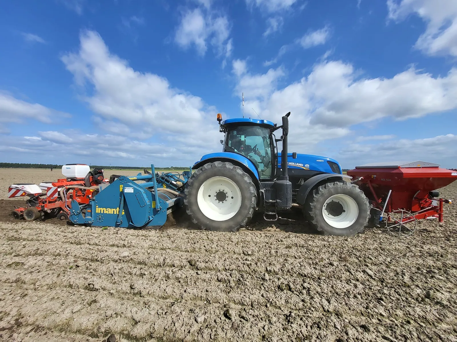 Trekker met Imants spitmachine en zaaimachine op een pas gespit perceel